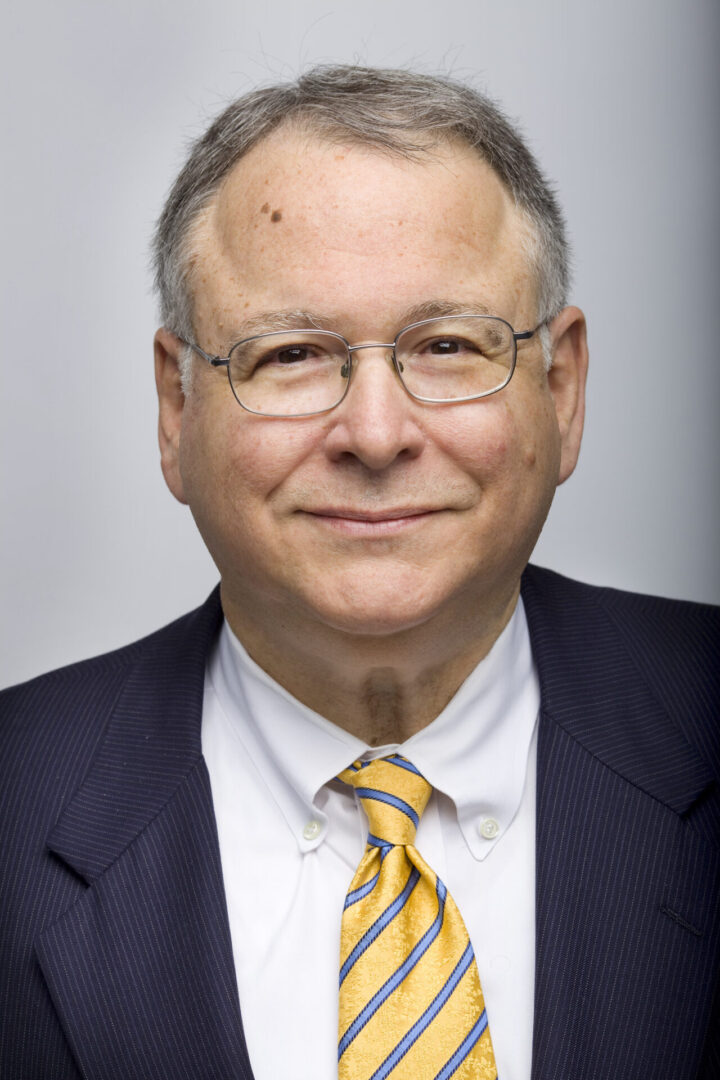 A man in a suit and tie smiling for the camera.